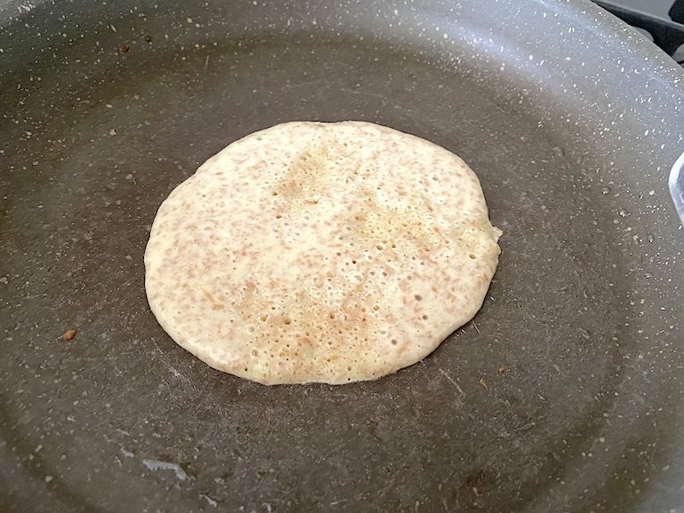 pancake in padella che inizia a fare le bolle, pronto per essere girato